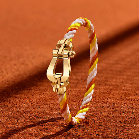 Bracelet en or jaune FRED x Roland-Garros avec cordon tressé blanc, jaune et orange.